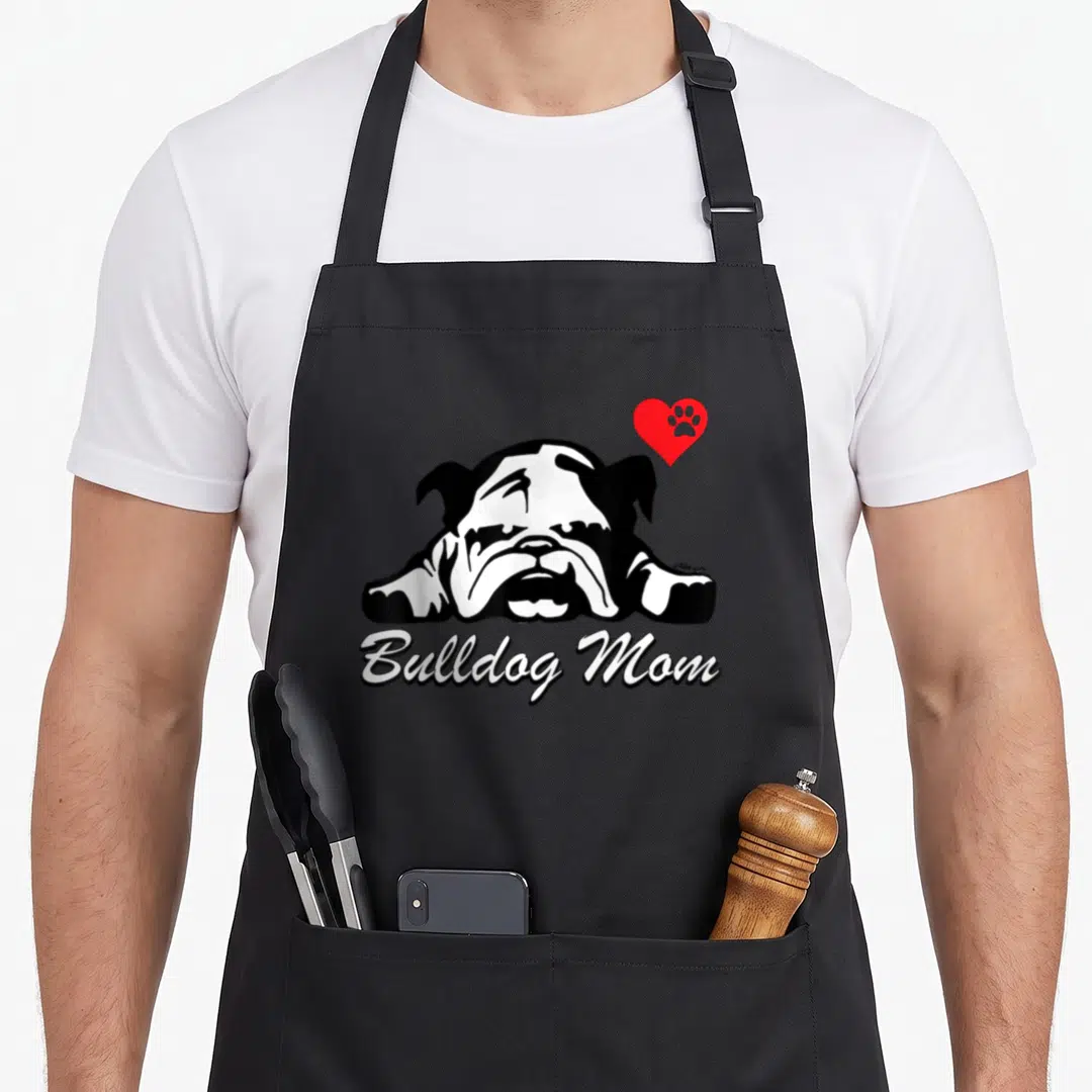 Cute bulldog english aprons - Black and white bulldog head with red heart paw print and Bulldog Mom script text — shown on a black cotton canvas apron against a white background