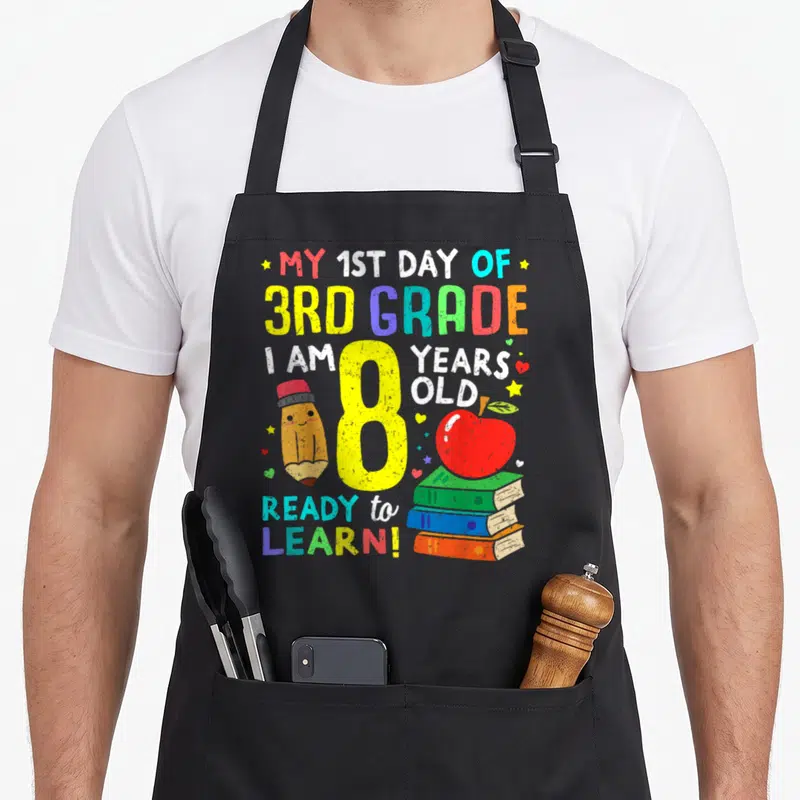 School grade apron - Yellow 8 with pencil books apple and My 1st Day of 3rd Grade text — shown on a black cotton canvas apron against a white background