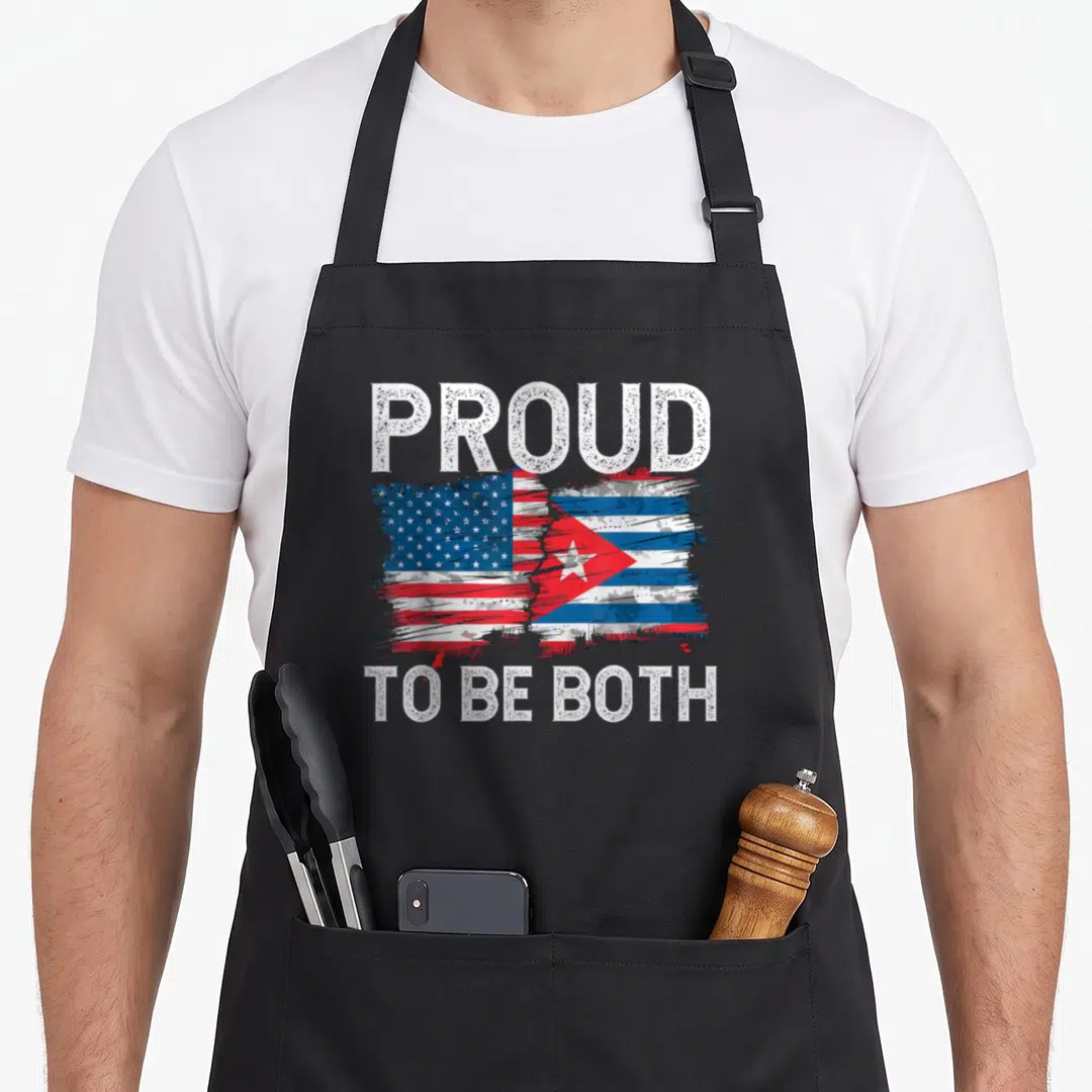Funny cuban american flag apron - Merged red white blue flags with distressed text proud to be both — shown on a black cotton canvas apron against a white background