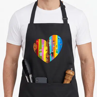 Many street apron - Heart with vertical red yellow blue green purple stripes containing cartoon characters — shown on a black cotton canvas apron against a white background