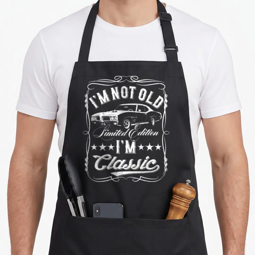 Vehicle cars apron - White distressed classic car and text I'M NOT OLD I'M Classic inside ornate border — shown on a black cotton canvas apron against a white background