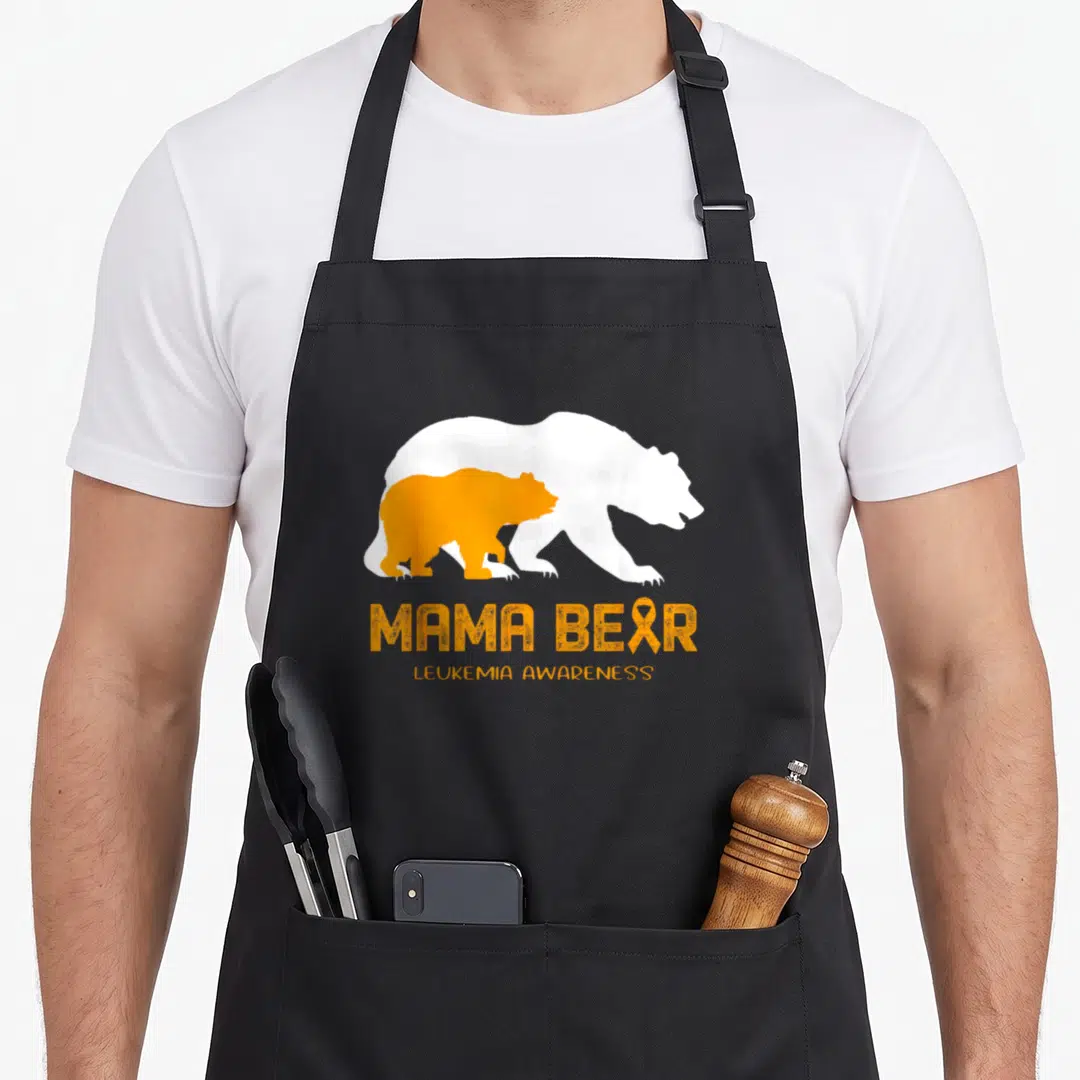 Leukemia mama bear apron - White and orange bear silhouettes with MAMA BEAR text and awareness ribbon — shown on a black cotton canvas apron against a white background