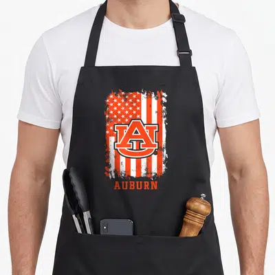 Elite patriotic apron - Auburn AU logo on distressed orange and white flag with text below — shown on a black cotton canvas apron against a white background