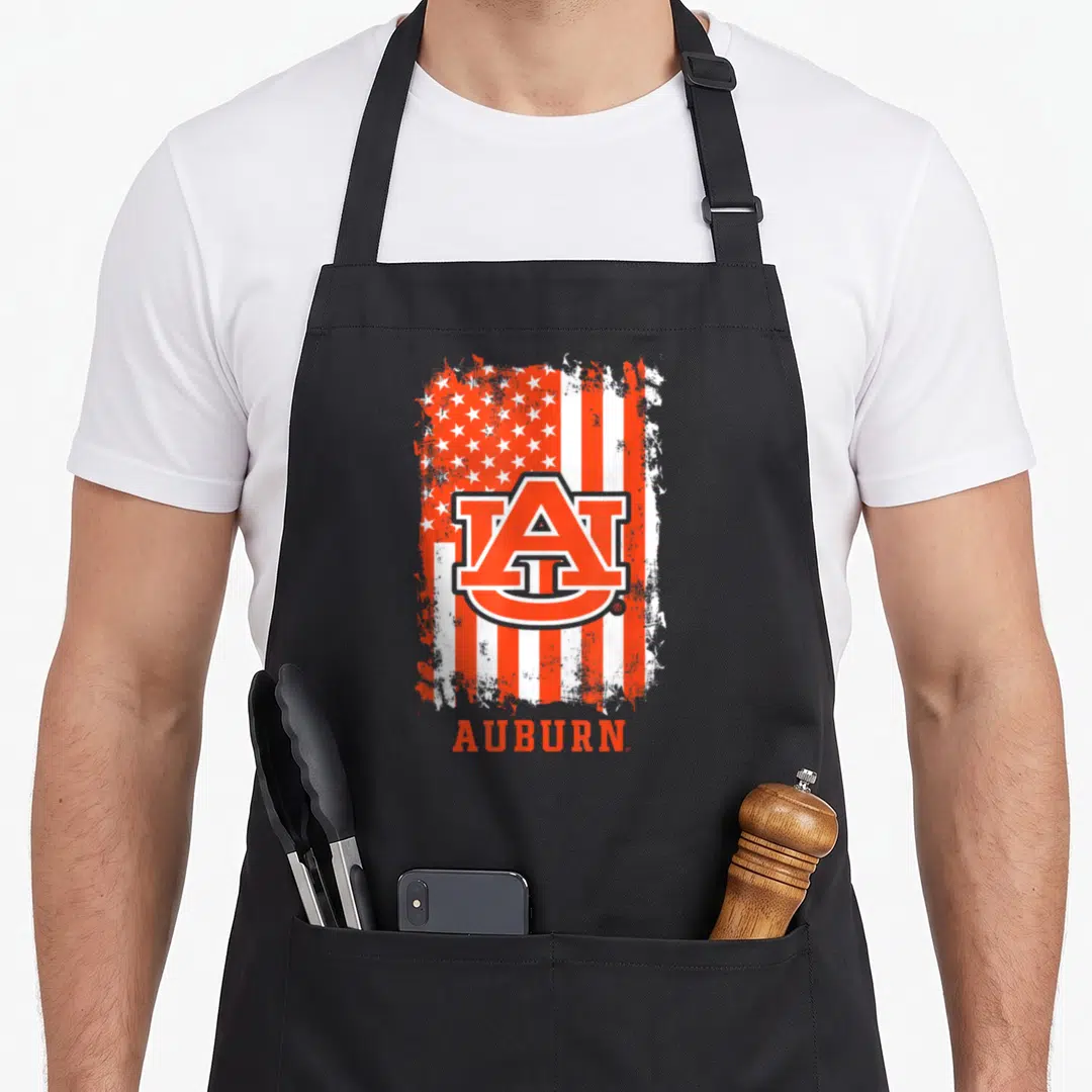 Elite patriotic apron - Auburn AU logo on distressed orange and white flag with text below — shown on a black cotton canvas apron against a white background
