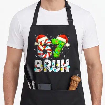 Bruh six christmas apron - Number 67 with Santa hats and lights below BRUH text — shown on a black cotton canvas apron against a white background