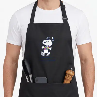 Funny beach apron - Snoopy holding colorful flowers with TAKE ME TO THE BEACH text below — shown on a black cotton canvas apron against a white background