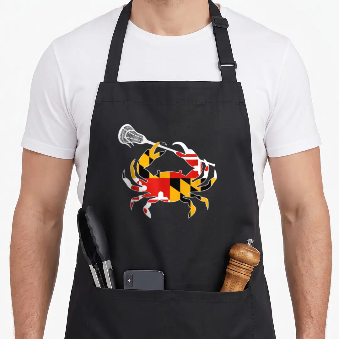 Lacrosse crab apron - Minimalist crab filled with red yellow black and white flag pattern holding a white lacrosse stick — shown on a black cotton canvas apron against a white background