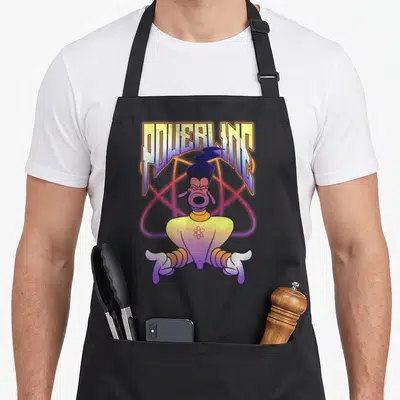 Movie x apron - POWERLINE text above cartoon dog character with atomic symbol on chest and large orbit background — shown on a black cotton canvas apron against a white background