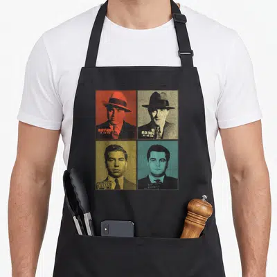 Gangster boss apron - Four distressed mugshot portraits in red, beige, yellow, blue with N.Y.C. POLICE text and booking — shown on a black cotton canvas apron against a white background