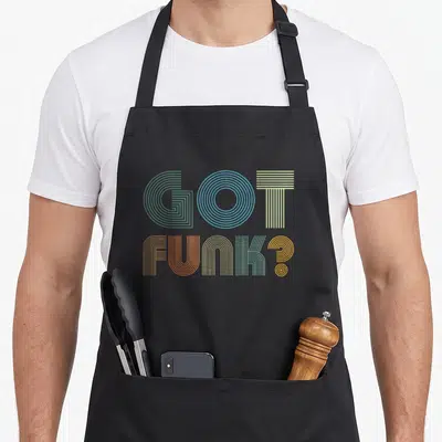 Funk vintage inspired apron - Stacked GOT FUNK? text in green blue yellow orange retro linear font — shown on a black cotton canvas apron against a white background