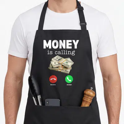 Business money apron - Stacked money pile with red decline and green accept phone buttons below white text — shown on a black cotton canvas apron against a white background