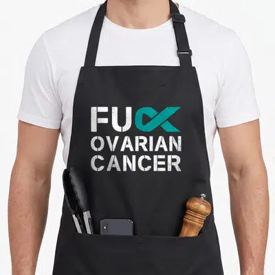 Ovarian cancer ribbon apron - Distressed white text FUC OVARIAN CANCER with teal ribbon replacing K in stacked layout — shown on a black cotton canvas apron against a white background