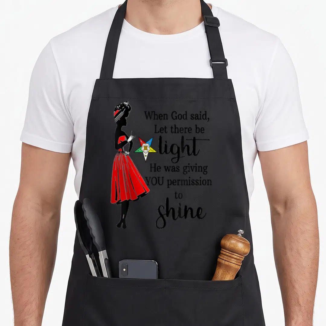 Permission ring apron - Woman silhouette in red dress beside colorful star and permission to shine text — shown on a black cotton canvas apron against a white background