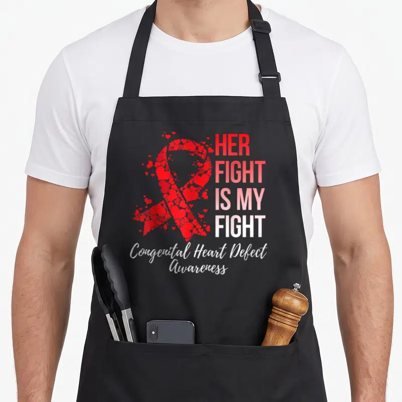 Fight congenital heart defect apron - Ribbon made of red hearts with stacked text Her Fight Is My Fight Congenital — shown on a black cotton canvas apron against a white background