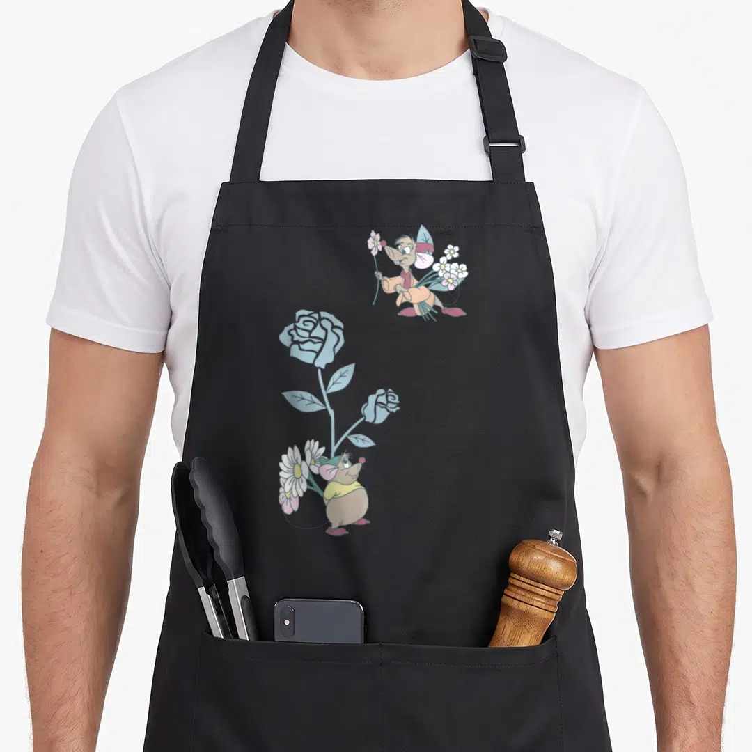 Gus cinderella apron - Two cartoon mice holding pink and white flowers next to a tall blue rose stem — shown on a black cotton canvas apron against a white background