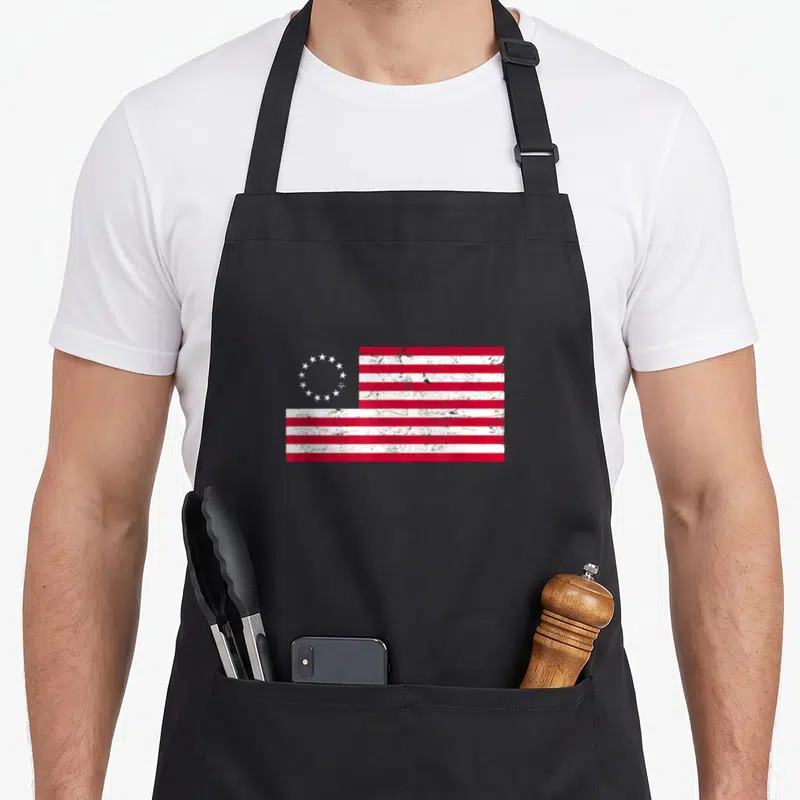 Distressed ross aprons - Red and white flag with circle of stars in distressed style — shown on a black cotton canvas apron against a white background