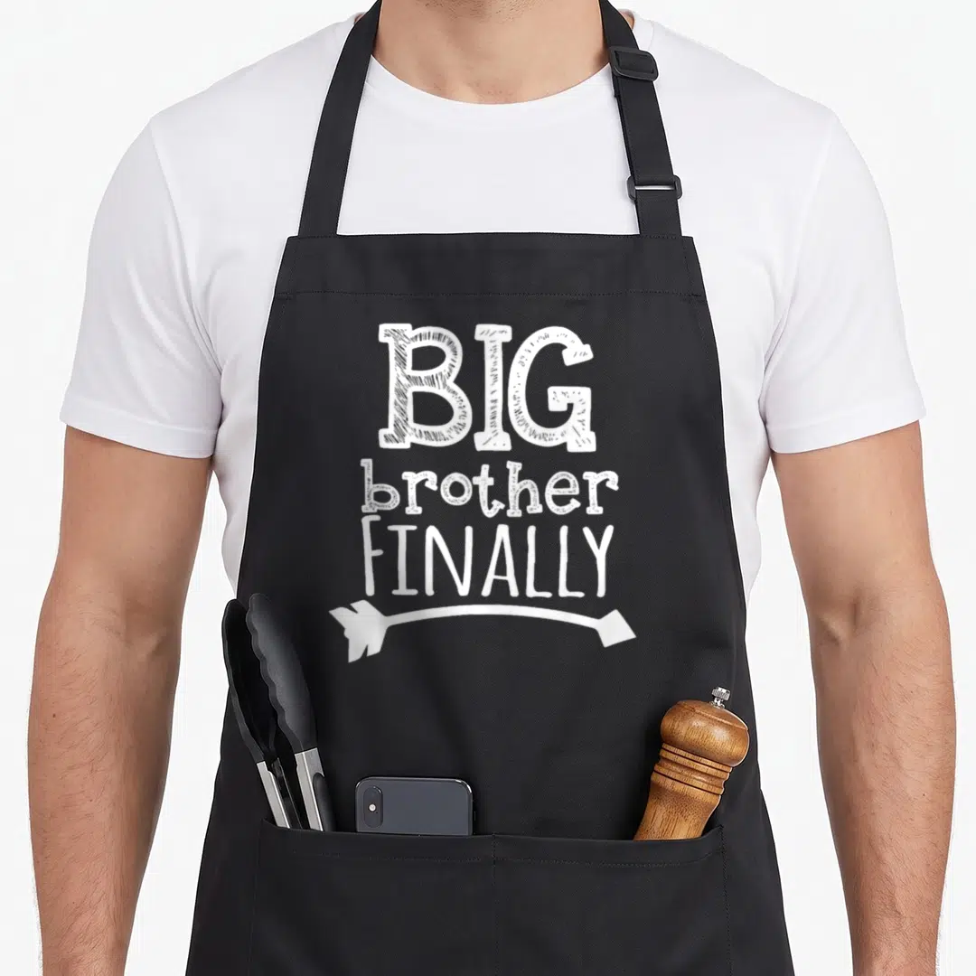 Finally brother love apron - White stacked text BIG brother FINALLY with curved arrow pointing left — shown on a black cotton canvas apron against a white background
