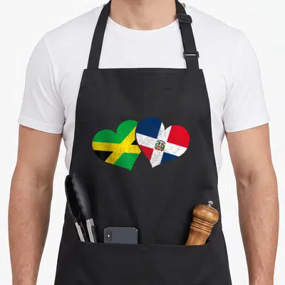 Jamaica dominican pride apron - Two overlapping hearts filled with Jamaican and Dominican Republic flags in green — shown on a black cotton canvas apron against a white background