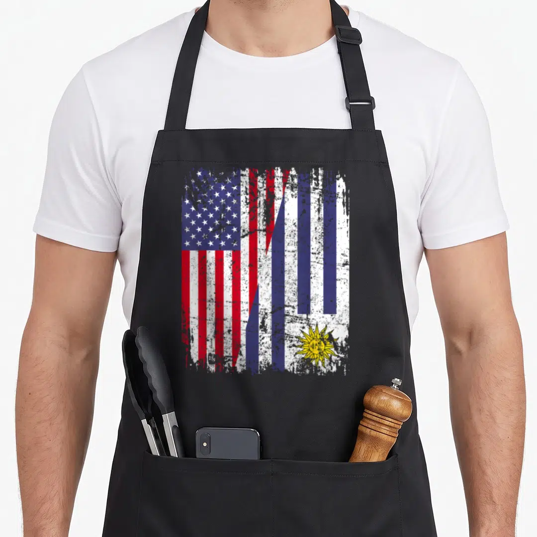 Uruguayan american flag apron - Distressed diagonal merge of USA and Uruguay flags in red white blue and yellow — shown on a black cotton canvas apron against a white background