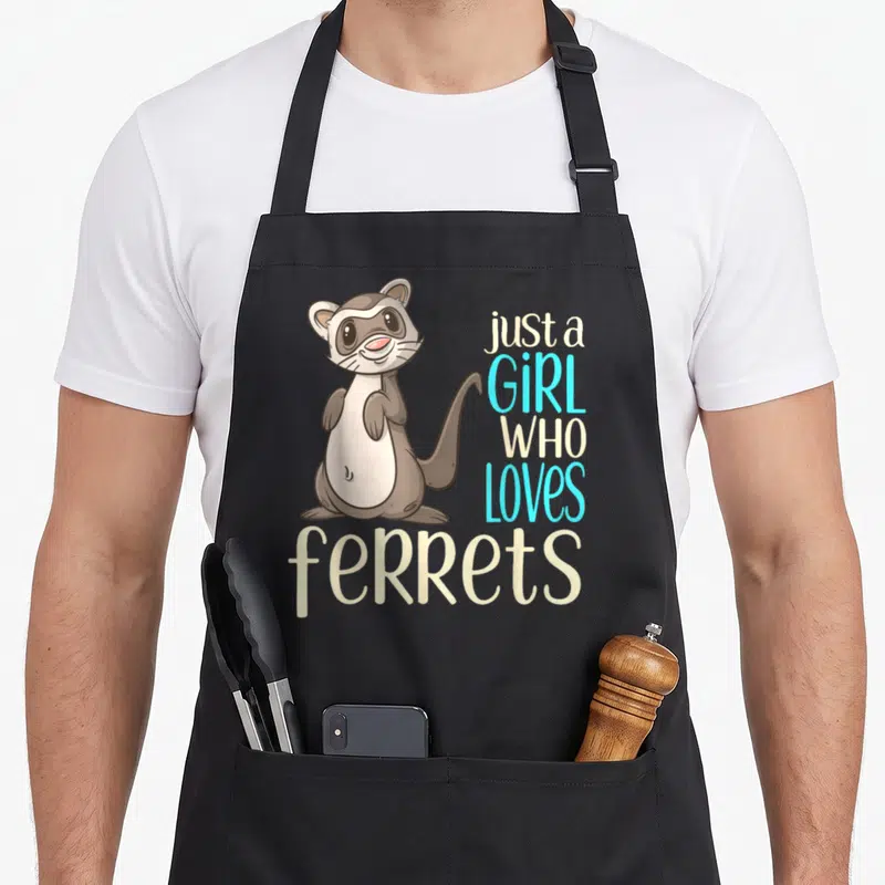 Funny crazy ferret lady apron - Cartoon brown ferret standing next to stacked text reading just a girl who loves ferrets — shown on a black cotton canvas apron against a white background