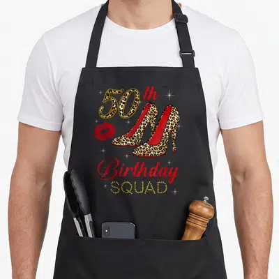 50th leopard apron - Leopard print high heels, red lips, and 50th birthday squad text design — shown on a black cotton canvas apron against a white background
