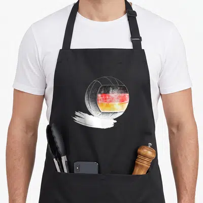 Volleyball german apron - Watercolor volleyball with German flag colors on white brush stroke — shown on a black cotton canvas apron against a white background