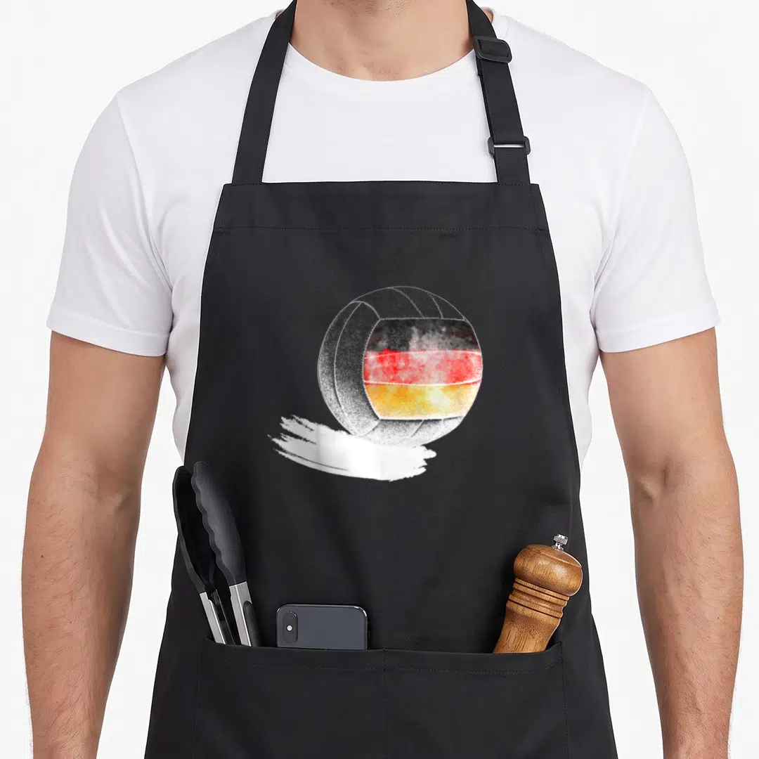 Volleyball german apron - Watercolor volleyball with German flag colors on white brush stroke — shown on a black cotton canvas apron against a white background
