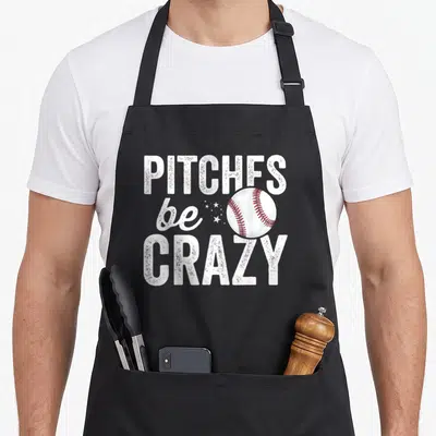 Pitch mother's apron - Pitches be crazy text with baseball and stars in white and red — shown on a black cotton canvas apron against a white background
