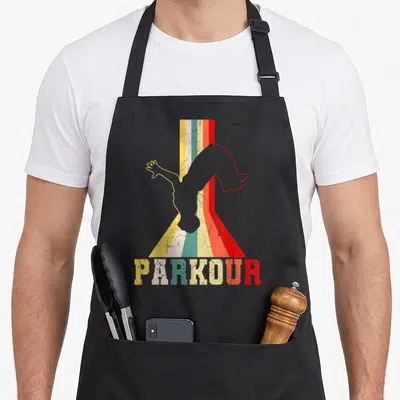 Freerunner traceur parkour apron - Retro parkour silhouette over flared yellow teal orange red white grey stripes — shown on a black cotton canvas apron against a white background