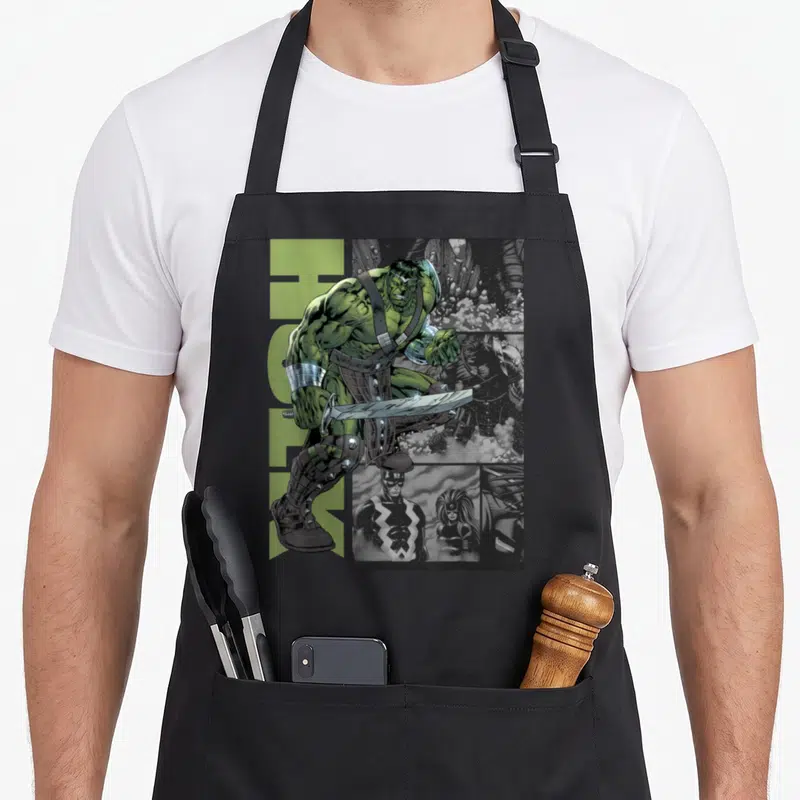 Universe war apron - Green Hulk figure holding sword over grey comic panels with two front pockets — shown on a black cotton canvas apron against a white background