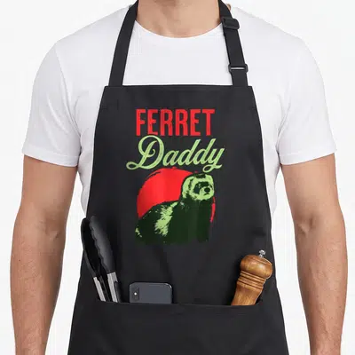 Ferret daddy apron - Distressed red and green text reading FERRET Daddy above a green ferret silhouette and red circle — shown on a black cotton canvas apron against a white background