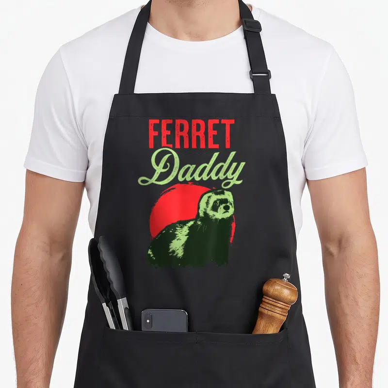Ferret daddy apron - Distressed red and green text reading FERRET Daddy above a green ferret silhouette and red circle — shown on a black cotton canvas apron against a white background