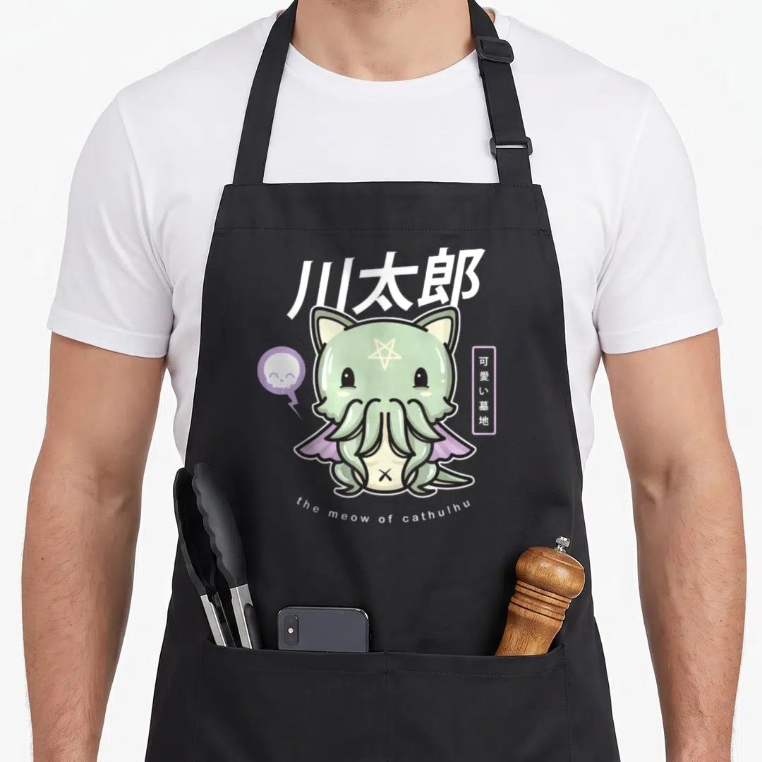 Meow goth apron - Green Cthulhu cat with pentagram, skull bubble, and white kanji text on black bib — shown on a black cotton canvas apron against a white background