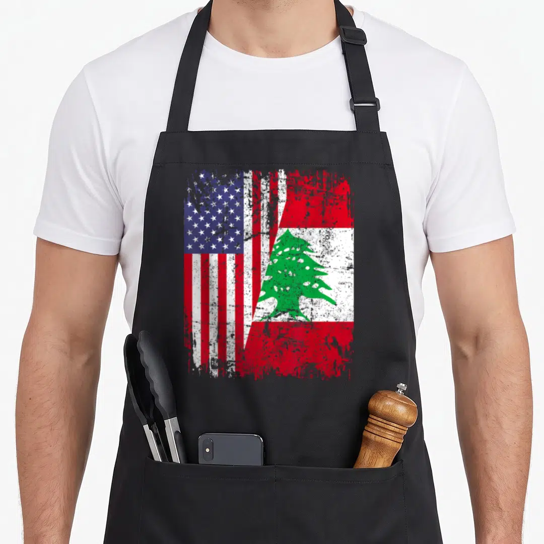 Lebanon american flag apron - Distressed merged US and Lebanon flags with red white blue green and a green cedar tree — shown on a black cotton canvas apron against a white background