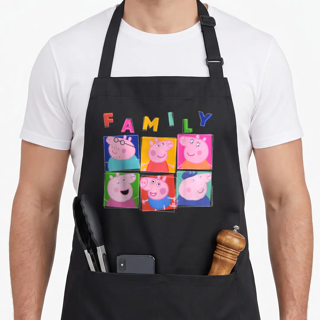 Box family aprons - Arched FAMILY text above six colored square portraits of a pig family in cartoon style — shown on a black cotton canvas apron against a white background