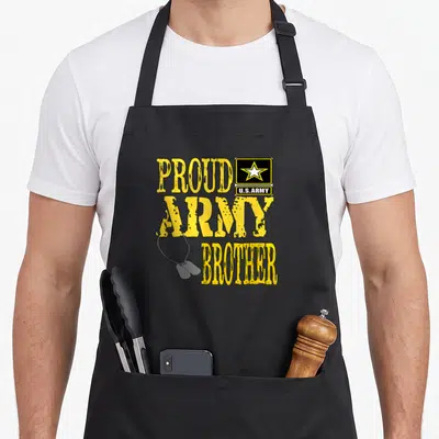 Proud military apron - Yellow Army Brother text with US Army patch and two hanging dog tags on black background — shown on a black cotton canvas apron against a white background