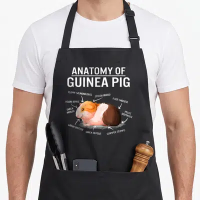 Anatomy mother's apron - Cartoon guinea pig diagram with labels floppy soundholders stylish hairdo and pellet dispenser — shown on a black cotton canvas apron against a white background