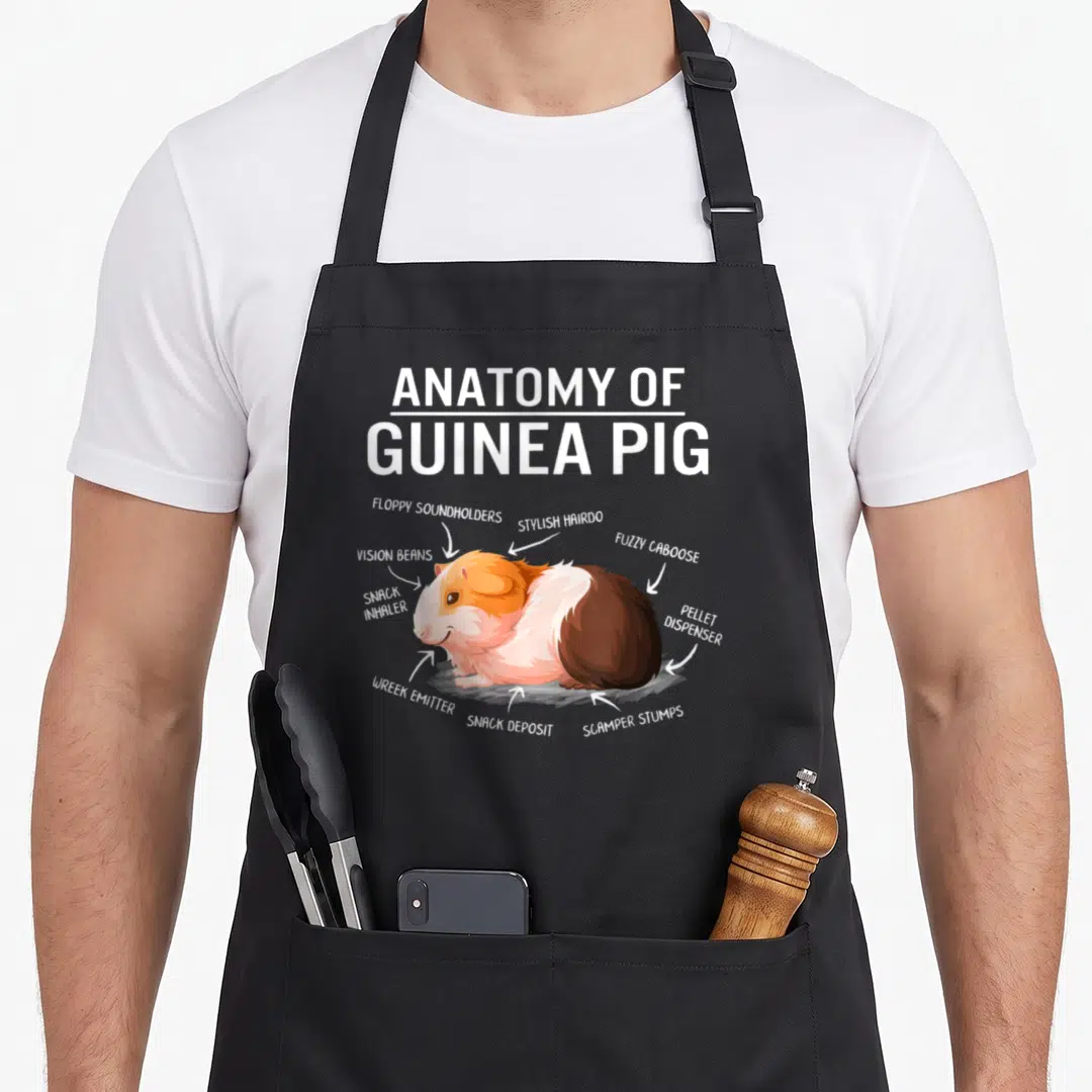 Anatomy mother's apron - Cartoon guinea pig diagram with labels floppy soundholders stylish hairdo and pellet dispenser — shown on a black cotton canvas apron against a white background