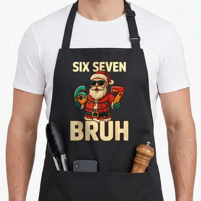 Meme christmas santa apron - Cartoon Santa holding donut 6 and 7 with Six Seven Bruh text — shown on a black cotton canvas apron against a white background