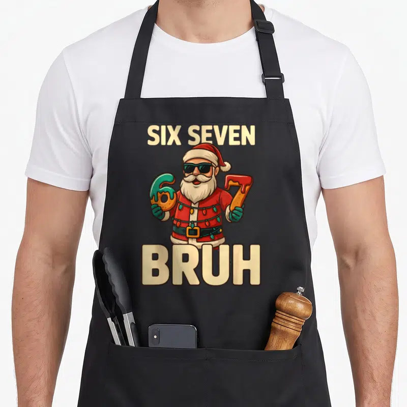 Meme christmas santa apron - Cartoon Santa holding donut 6 and 7 with Six Seven Bruh text — shown on a black cotton canvas apron against a white background