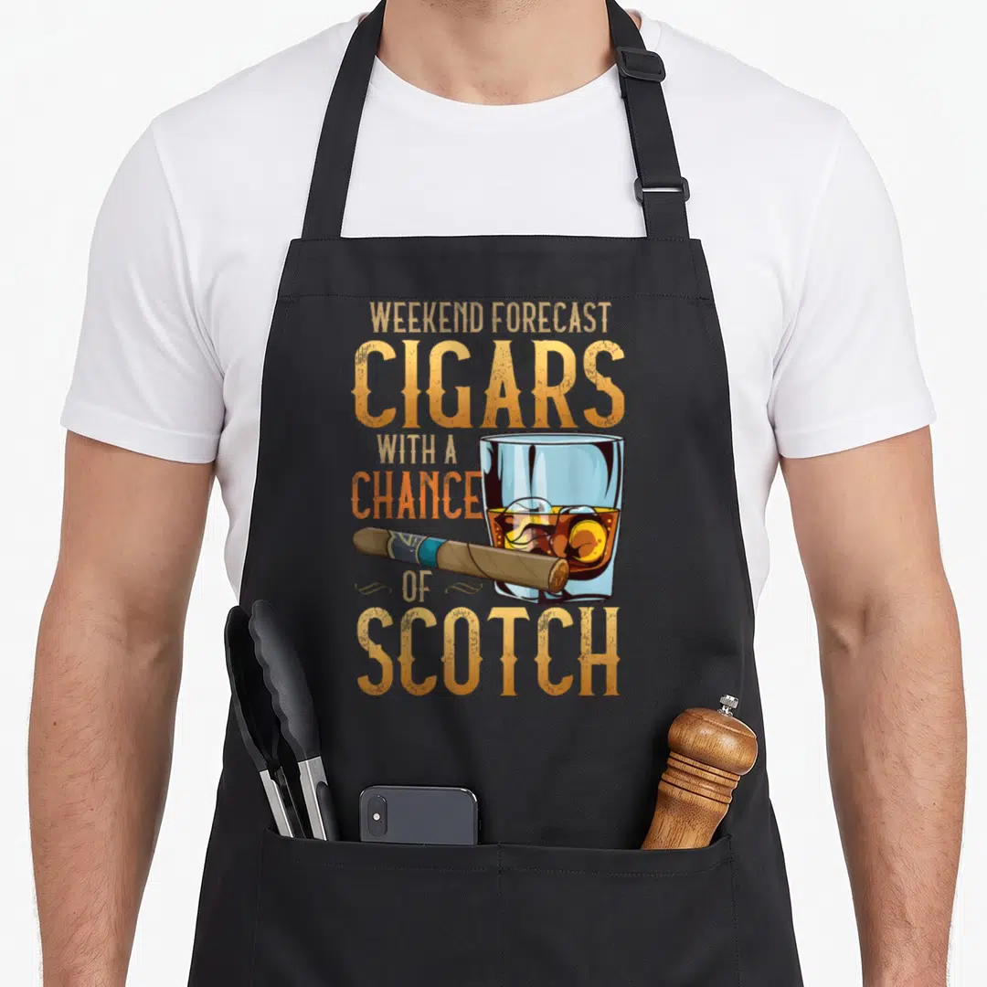 Weekend cuban apron - Stacked gold text reading Weekend Forecast Cigars With A Chance Of Scotch above a scotch glass — shown on a black cotton canvas apron against a white background