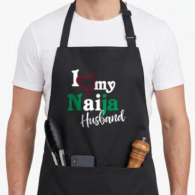 Naija couple apron - I my Naija Husband text with red heart outline in white and green — shown on a black cotton canvas apron against a white background