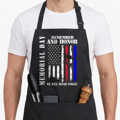 Remember memorial apron - Distressed US flag with helicopter soldier tank silhouettes and memorial day text — shown on a black cotton canvas apron against a white background