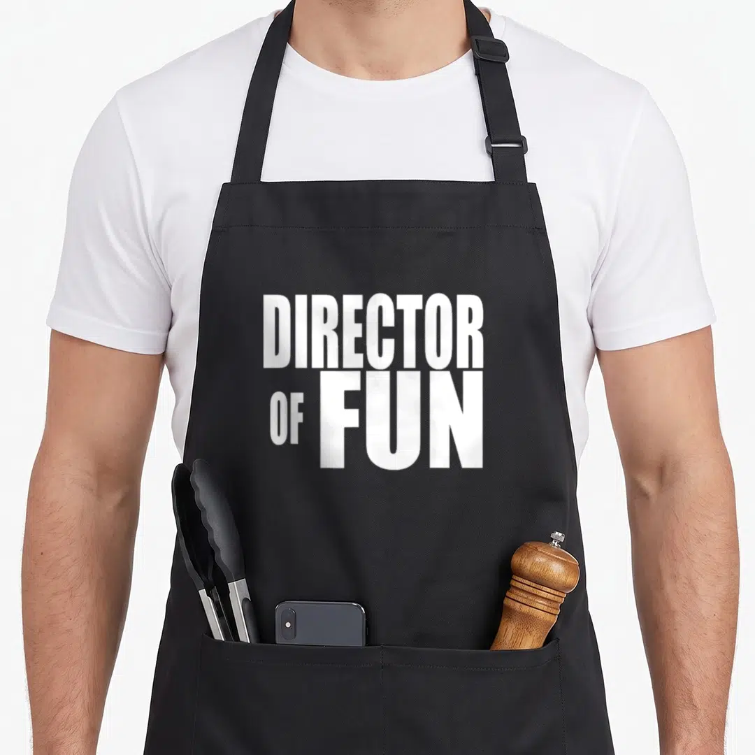 Director wedding planner apron - White stacked text reading DIRECTOR OF FUN on grey background — shown on a black cotton canvas apron against a white background