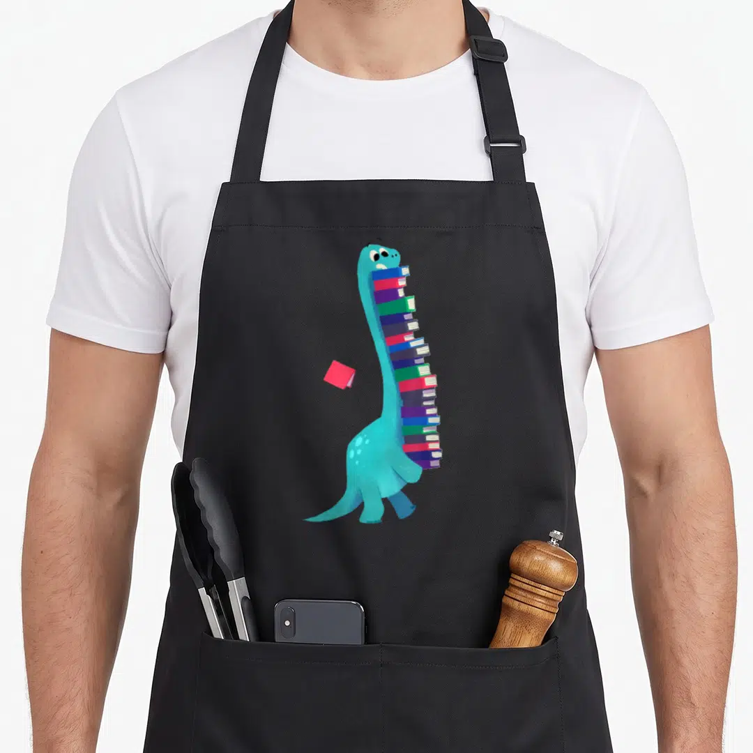 Book dinosaur apron - Blue cartoon dinosaur facing right carrying a stack of multi-colored books with one red book — shown on a black cotton canvas apron against a white background