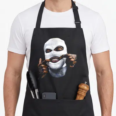 Gangster hip apron - Person in white balaclava pulling open mouth to show gold teeth — shown on a black cotton canvas apron against a white background
