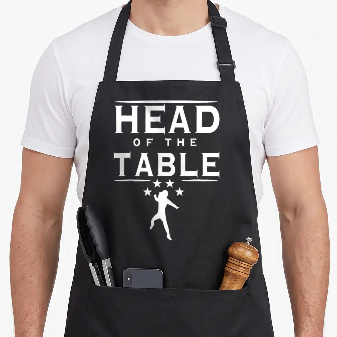 Funny table apron - White text Head of the Table above dancing person silhouette and four stars — shown on a black cotton canvas apron against a white background