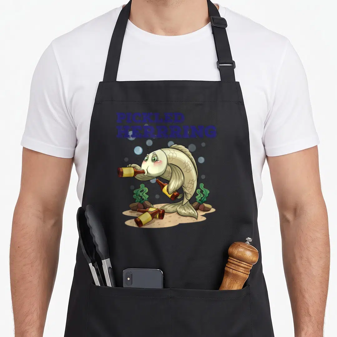 Pickled fish apron - Cartoon herring drinking bottle with blue text on sandy seabed — shown on a black cotton canvas apron against a white background
