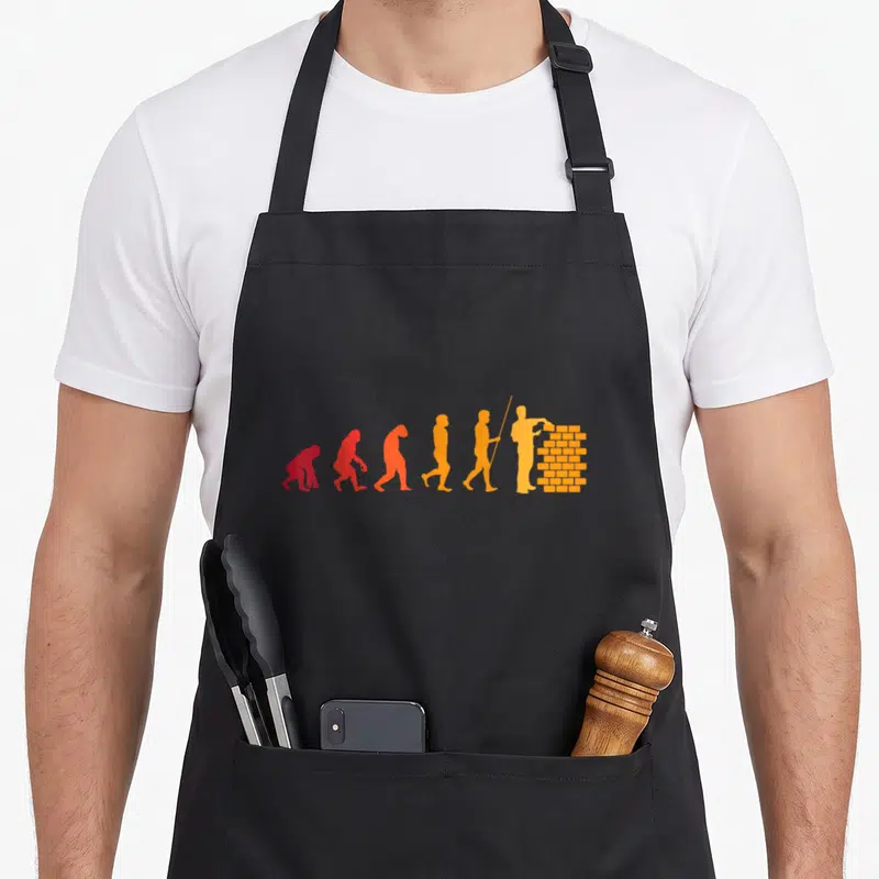 Bricklayer builder apron - Six silhouettes evolving from ape to bricklayer in red orange and yellow gradient — shown on a black cotton canvas apron against a white background