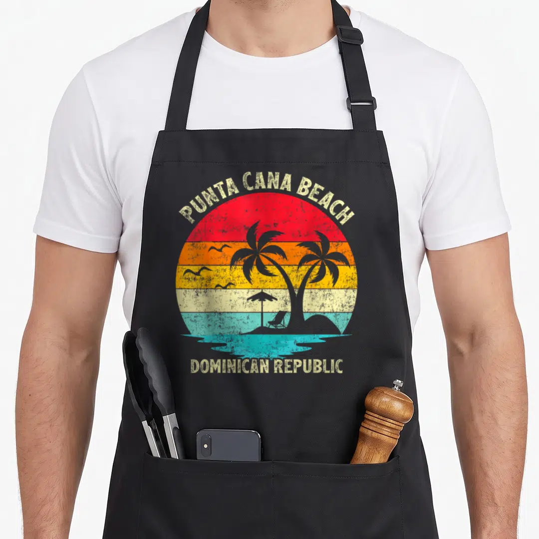 Republic family aprons - Retro circular sunset with palm trees and Punta Cana Beach Dominican Republic text — shown on a black cotton canvas apron against a white background